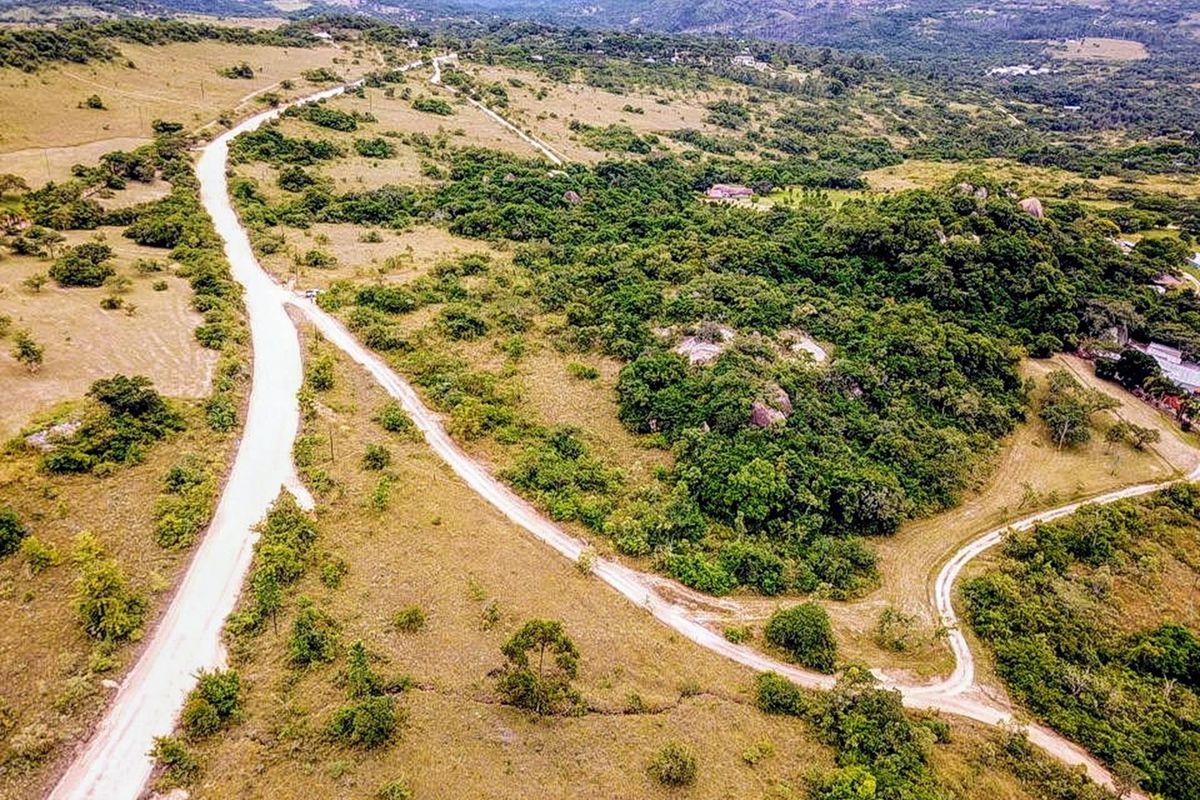 An aerial view of the small holding property showcasing the expansive natural landscape, indigenous vegetation, rock formations, and gravel access roads.