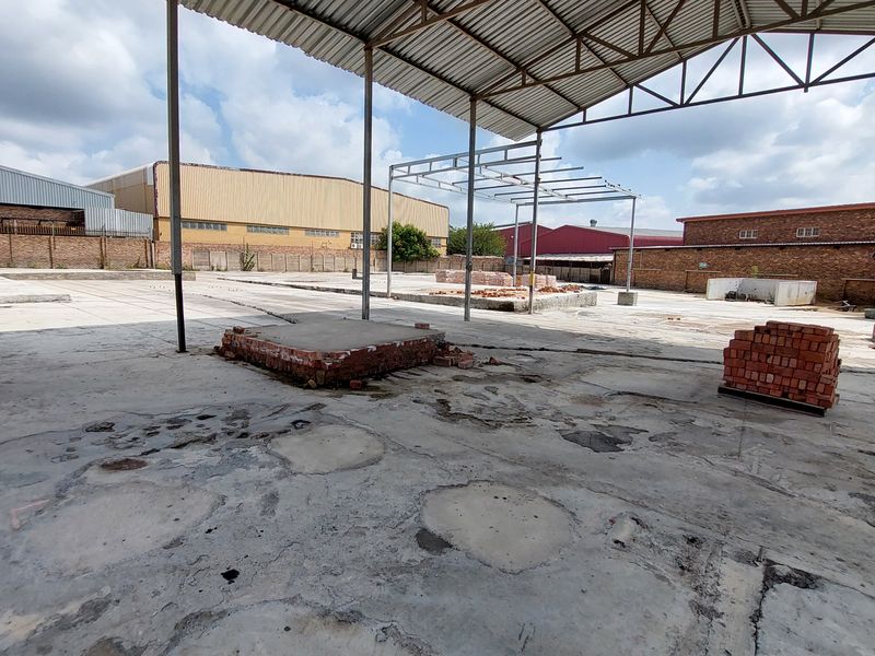 Expansive industrial utility space featuring a large concrete slab, steel roof structure, and perimeter brick walling, suitable for various commercial or storage applications.