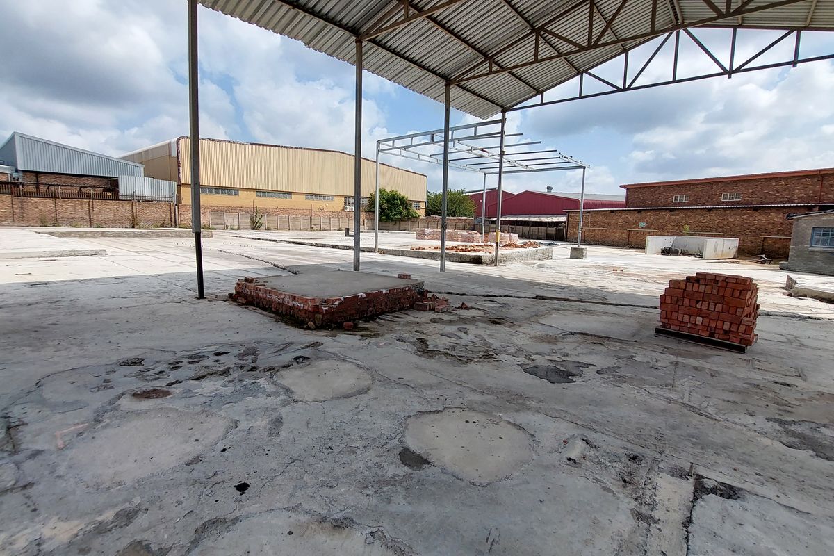 Expansive industrial utility space featuring a large concrete slab, steel roof structure, and perimeter brick walling, suitable for various commercial or storage applications.