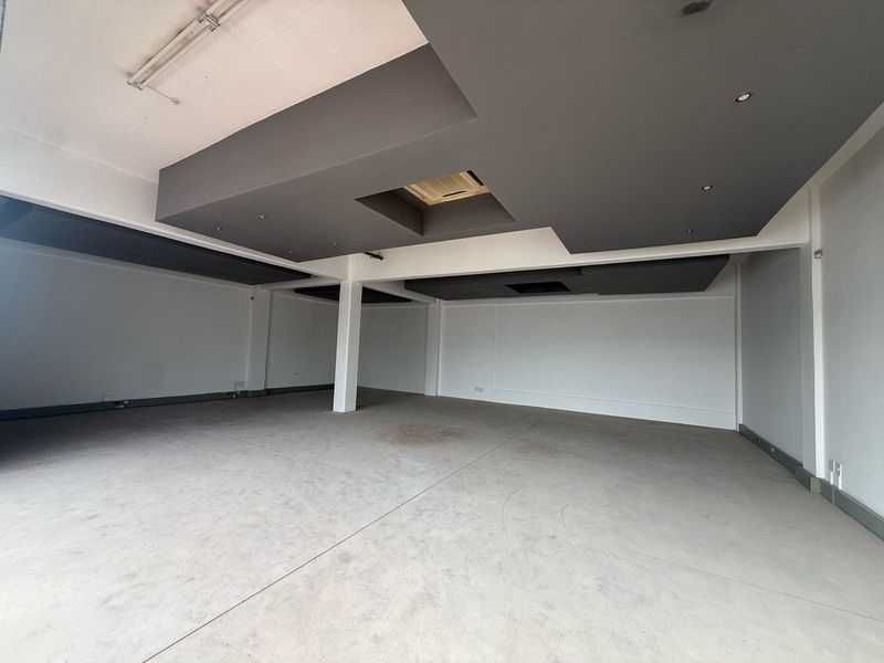 Spacious open-plan retail area featuring modern recessed ceiling bulkheads, integrated lighting, and durable concrete flooring, suitable for a variety of commercial business layouts.