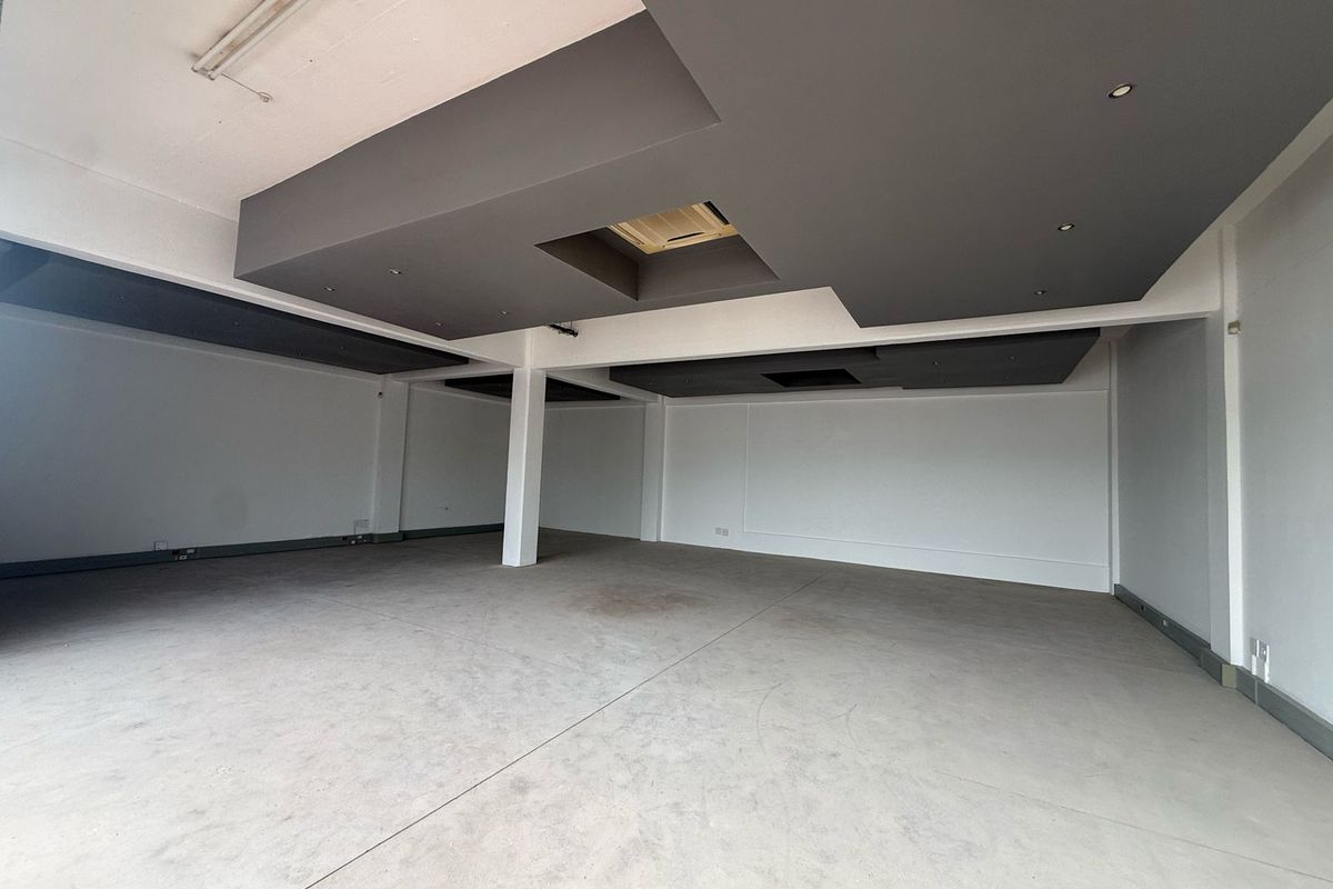 Spacious open-plan retail area featuring modern recessed ceiling bulkheads, integrated lighting, and durable concrete flooring, suitable for a variety of commercial business layouts.