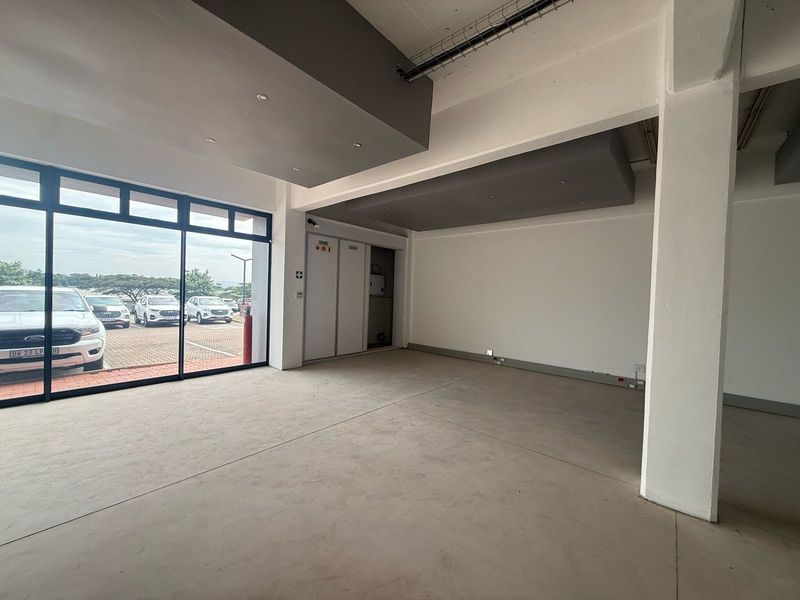 Spacious open-plan retail unit featuring large glass frontage, modern recessed ceiling bulkheads, and polished concrete flooring, suitable for various commercial business applications.