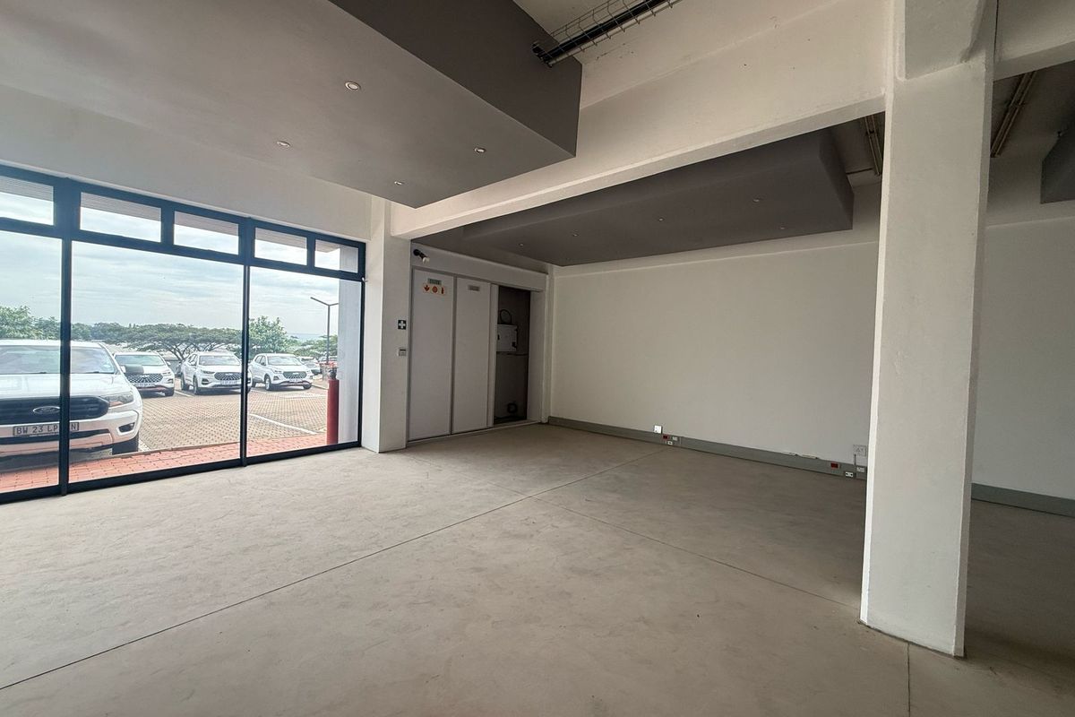 Spacious open-plan retail unit featuring large glass frontage, modern recessed ceiling bulkheads, and polished concrete flooring, suitable for various commercial business applications.