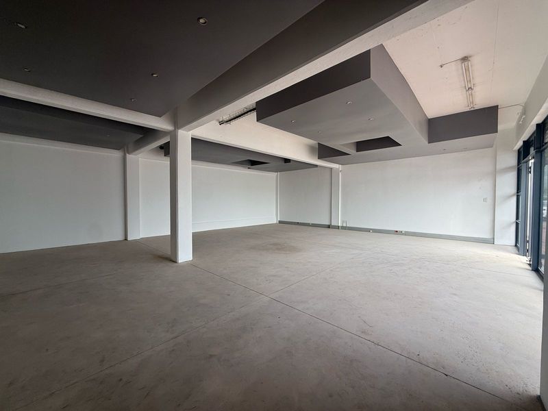 Spacious open-plan retail unit featuring polished concrete floors, modern dropped ceiling bulkheads with recessed lighting, and a large glass storefront for maximum visibility.
