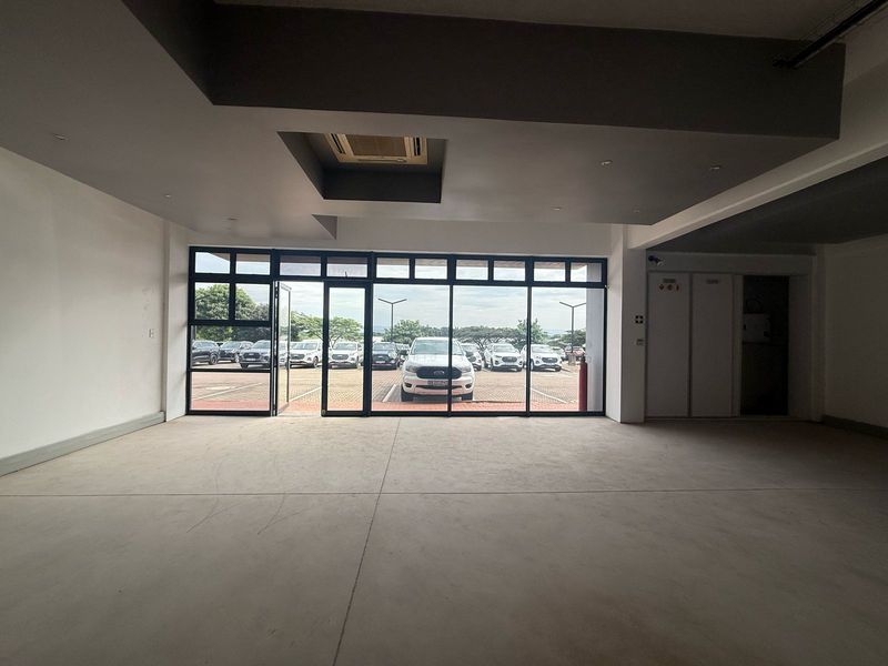 Spacious open-plan retail unit featuring polished concrete floors, recessed ceiling details, and large glass storefront windows providing ample natural light and parking views.
