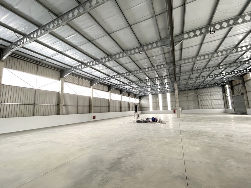 Spacious industrial warehouse featuring a high-clearance steel portal frame, polished concrete flooring, and ample natural light through high-level windows.