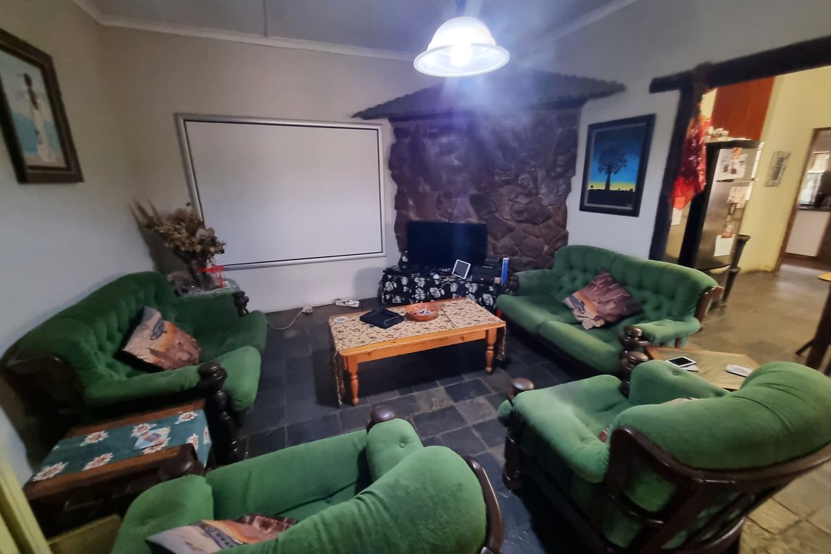 A cozy living room featuring a rustic stone feature wall, durable slate tile flooring, and a central pendant light fixture.