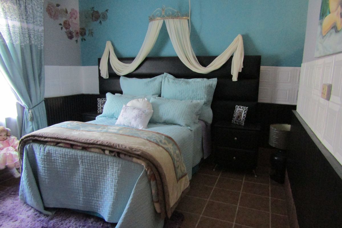 A bedroom featuring tiled flooring and decorative wainscoting, providing a functional space with a distinct color scheme.