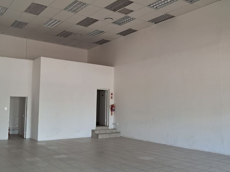 Spacious open-plan retail area featuring tiled flooring, suspended ceilings with recessed lighting, and neutral walls, suitable for various commercial business applications.