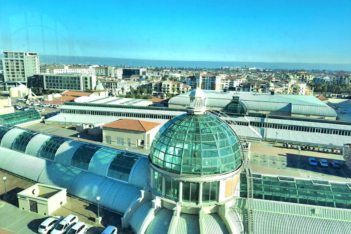 Elevated aerial view overlooking a commercial office complex featuring a prominent glass dome structure and surrounding urban landscape.