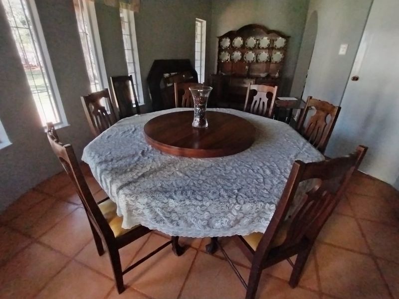 A dining room featuring terracotta floor tiles and an arched doorway, providing a traditional layout for family meals.