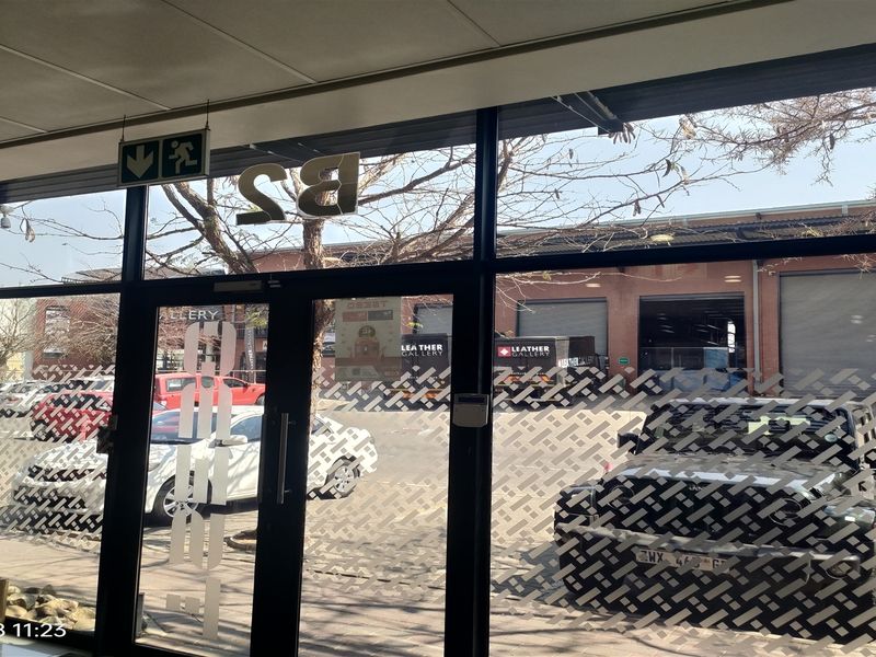 Interior view of an industrial unit entrance featuring a glass storefront with aluminum framing and frosted privacy film.
