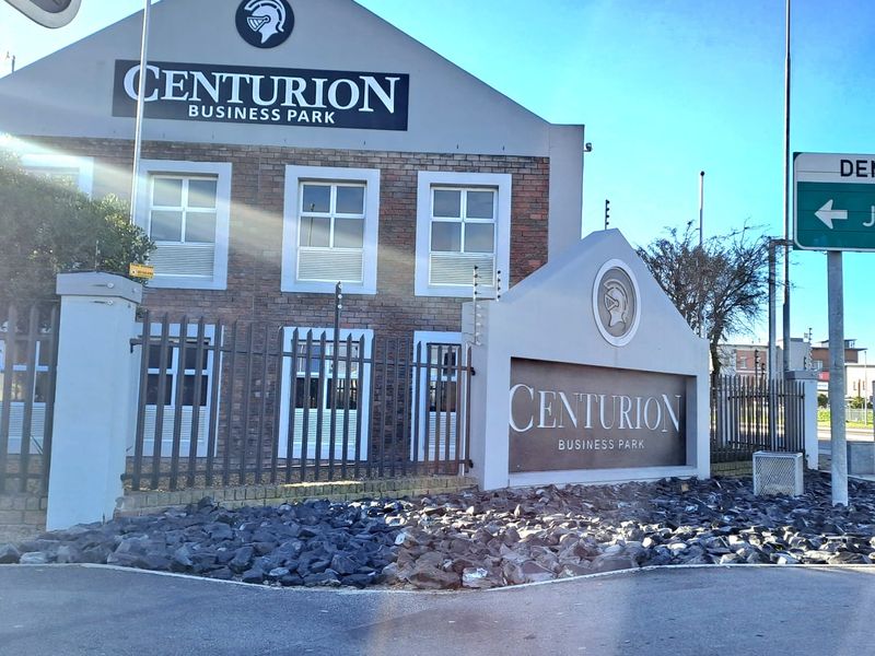 Front exterior view of Centurion Business Park featuring brick facade, secure perimeter fencing, and professional signage.