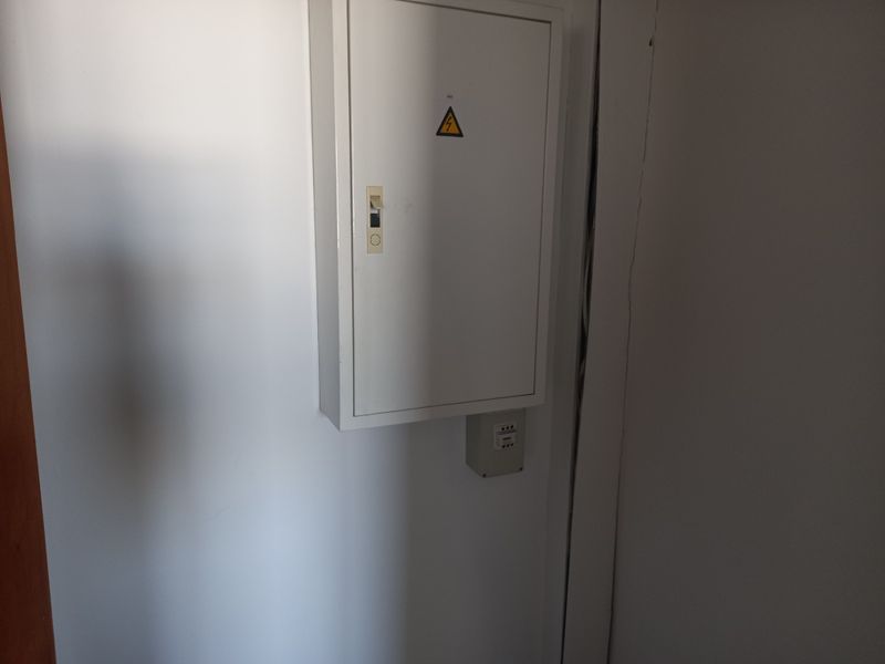 A utility area featuring a wall-mounted electrical distribution board and associated junction box.