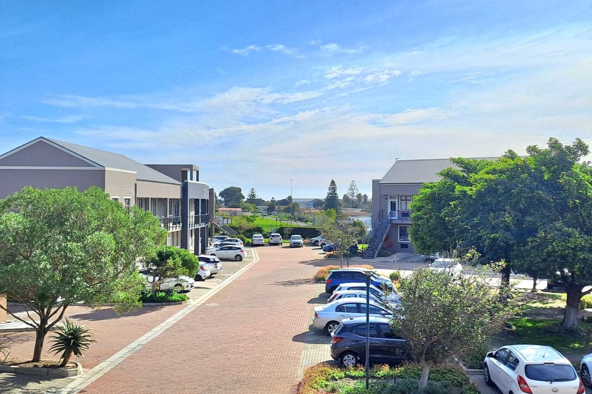An elevated view of the office park complex featuring paved driveways, landscaped garden beds, and dedicated parking areas between the building structures.