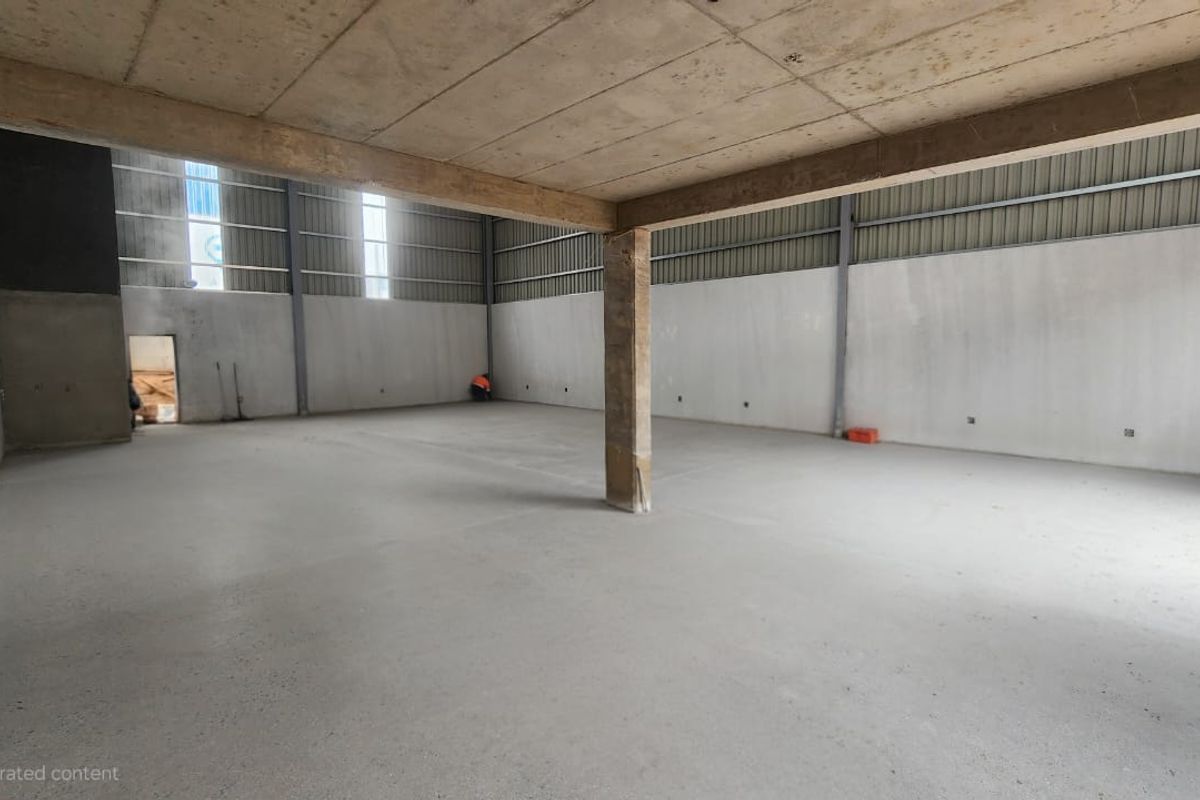 Spacious industrial utility area featuring concrete flooring, exposed ceiling, and steel structural support, suitable for warehouse or workshop use.
