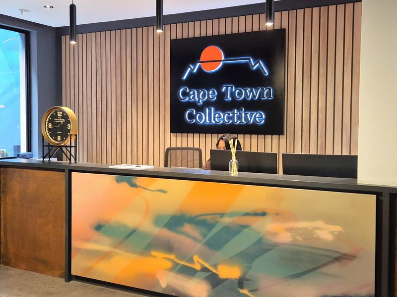 Modern office reception area featuring a custom-designed desk, timber slat feature wall, and professional branding signage.