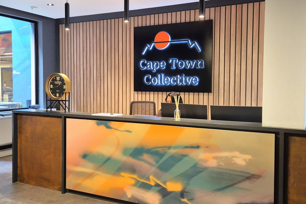 Modern office reception area featuring a custom-designed desk, timber slat feature wall, and professional branding signage.