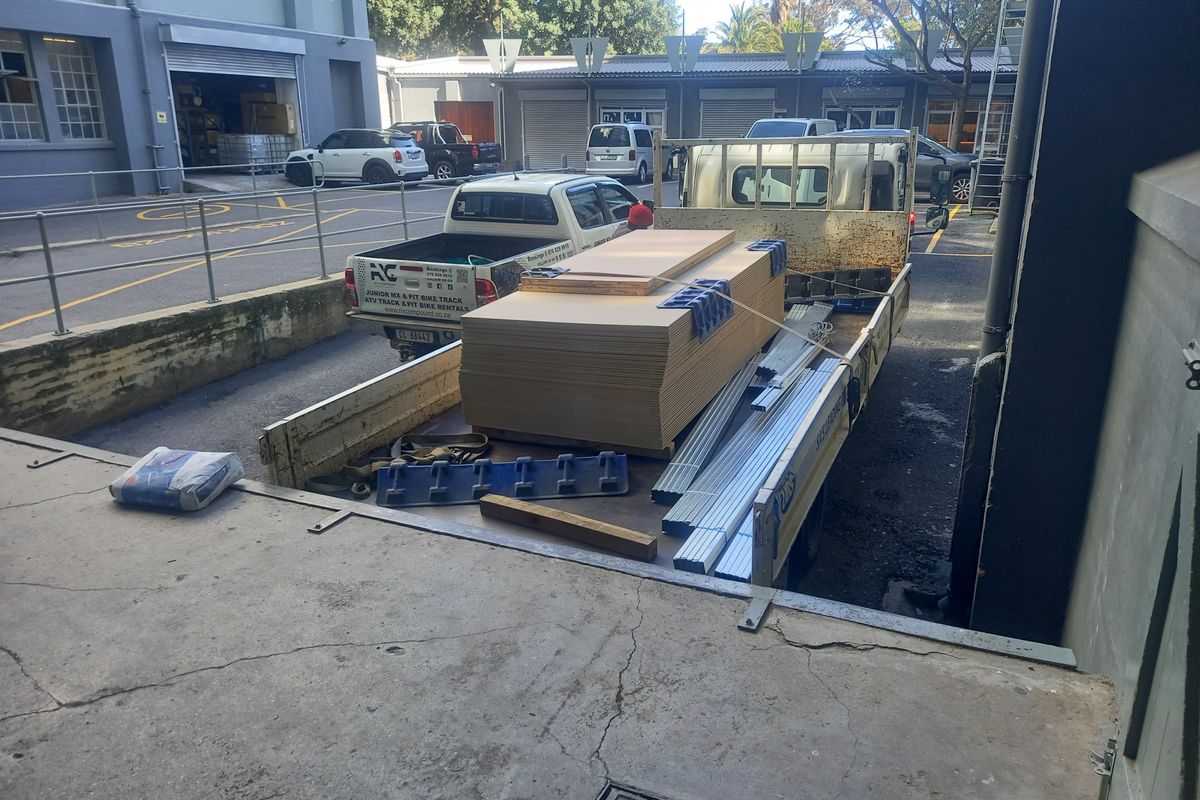 Industrial loading bay area with concrete ramp and access to multiple roller shutter doors, showing standard operational wear.
