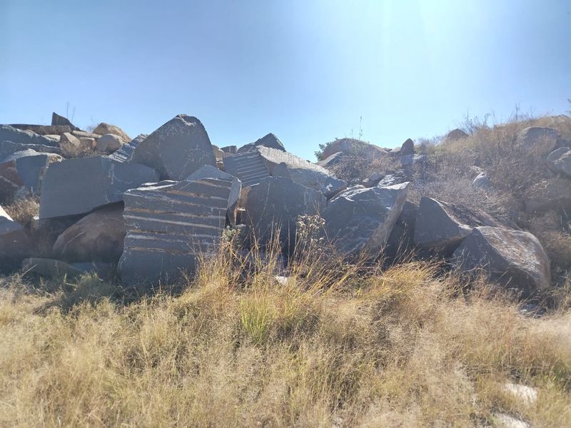 A natural landscape view featuring large rock formations and dry grass on the farm property.