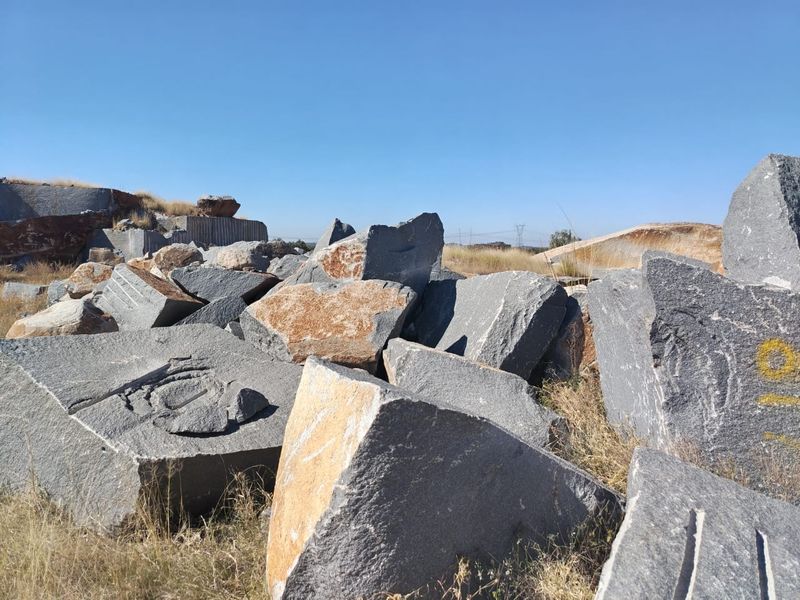 An outdoor area featuring large quarried stone blocks and natural rock formations on the farm property.