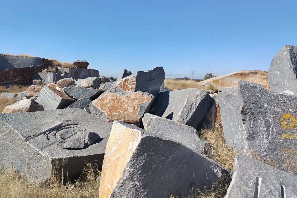 An outdoor area featuring large quarried stone blocks and natural rock formations on the farm property.
