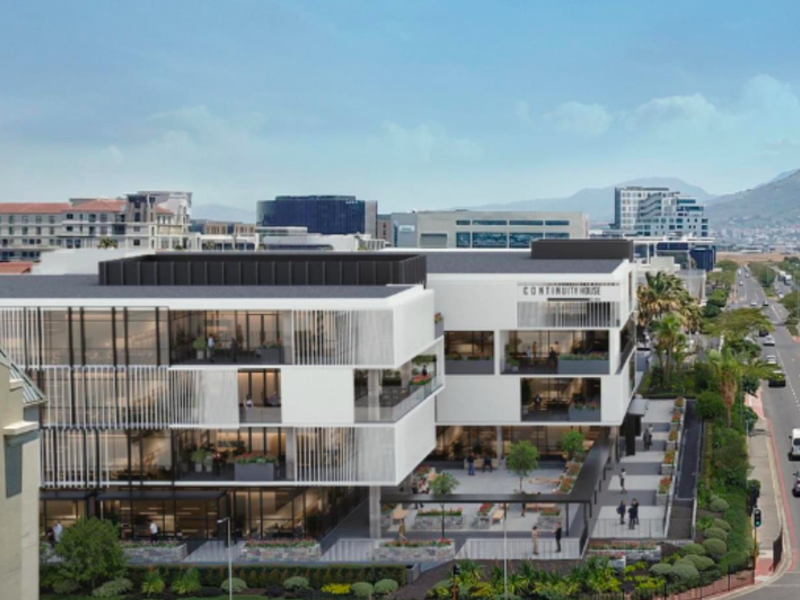 Aerial view of a modern multi-story office building featuring contemporary architectural design, glass facades, and integrated landscaped outdoor spaces.