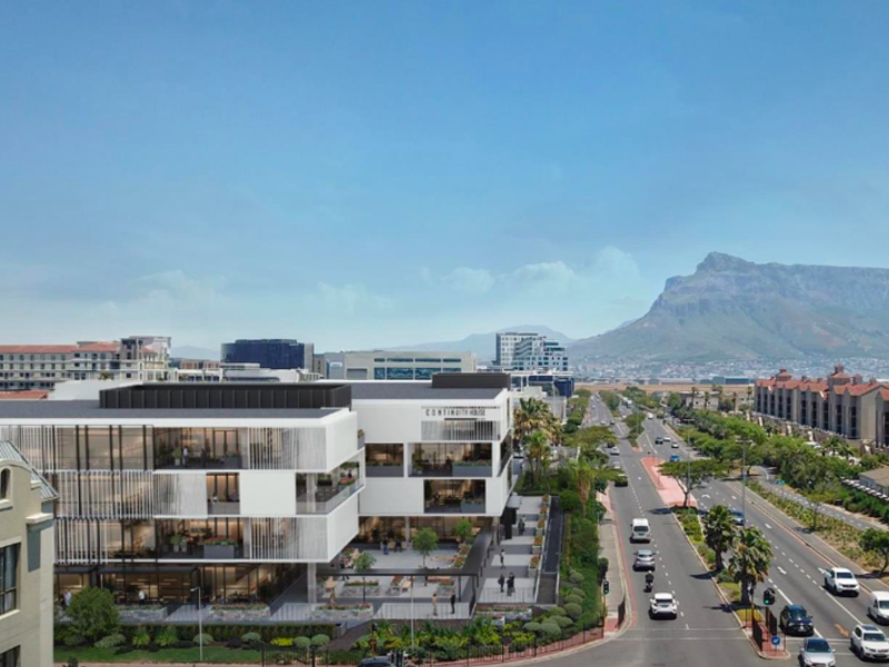 Aerial view of a modern office building complex featuring contemporary architecture, balconies, and landscaped surroundings with mountain views in the background.