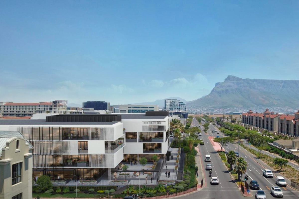 Aerial view of a modern office building complex featuring contemporary architecture, balconies, and landscaped surroundings with mountain views in the background.