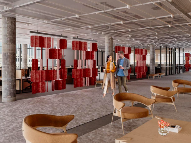 Modern open-plan office space featuring exposed concrete columns, high suspended ceilings, and floor-to-ceiling glass partitions, creating a bright and professional work environment.