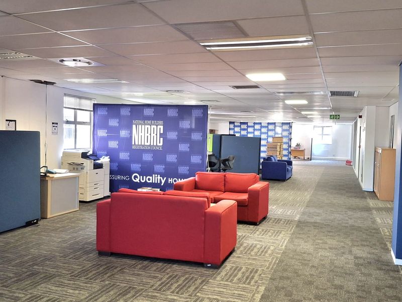 Spacious open-plan office area featuring suspended ceilings, recessed lighting, and durable carpet tiles, suitable for a professional corporate environment.