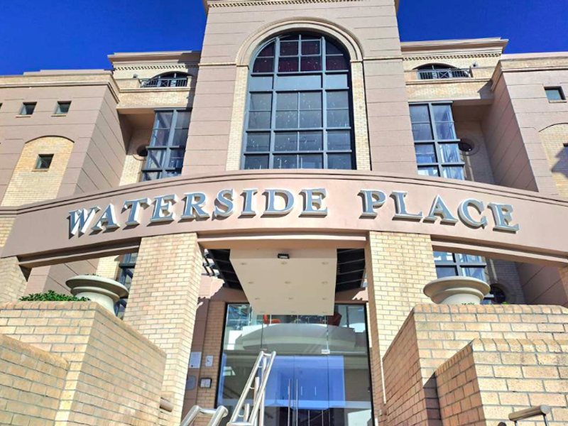 Front elevation of Waterside Place office building featuring a prominent arched window, brick masonry, and a modern glass entrance.