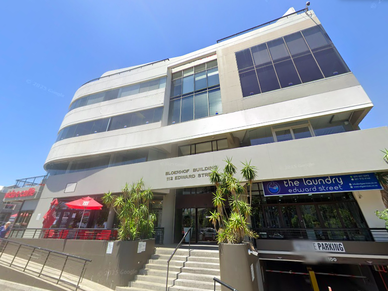 Front elevation of the Bloemhof Building, a multi-story commercial office property featuring glass facade elements and integrated ground-level retail and parking access.