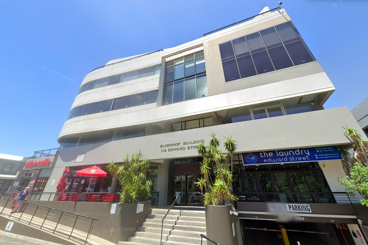 Front elevation of the Bloemhof Building, a multi-story commercial office property featuring glass facade elements and integrated ground-level retail and parking access.