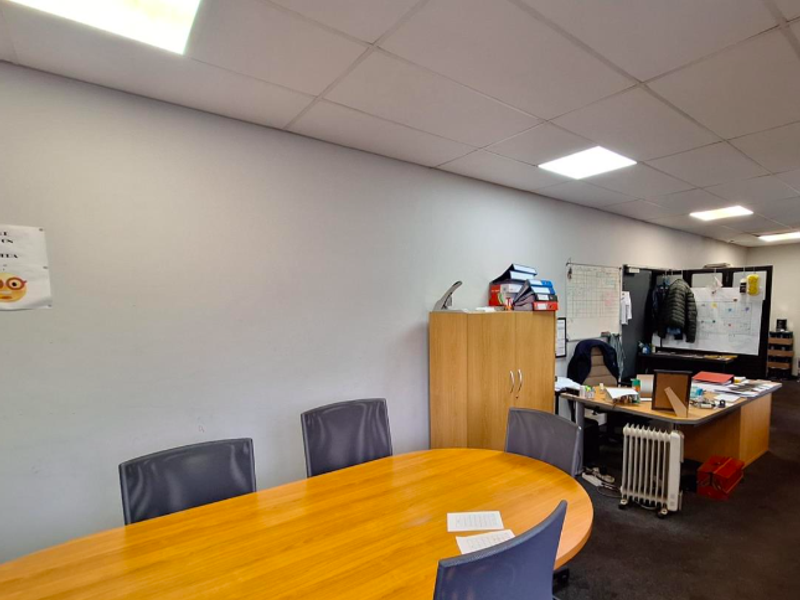 A functional office space featuring a suspended ceiling with recessed lighting, suitable for a professional work environment.