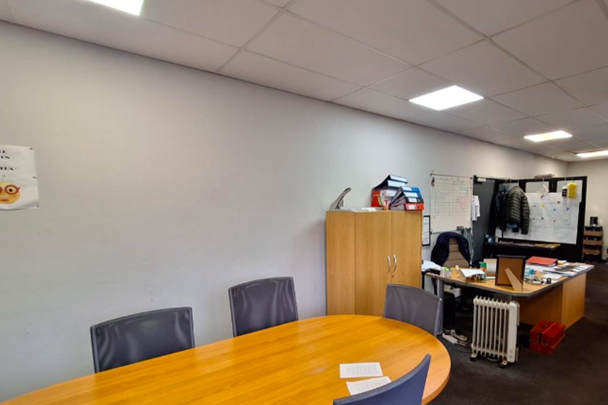 A functional office space featuring a suspended ceiling with recessed lighting, suitable for a professional work environment.