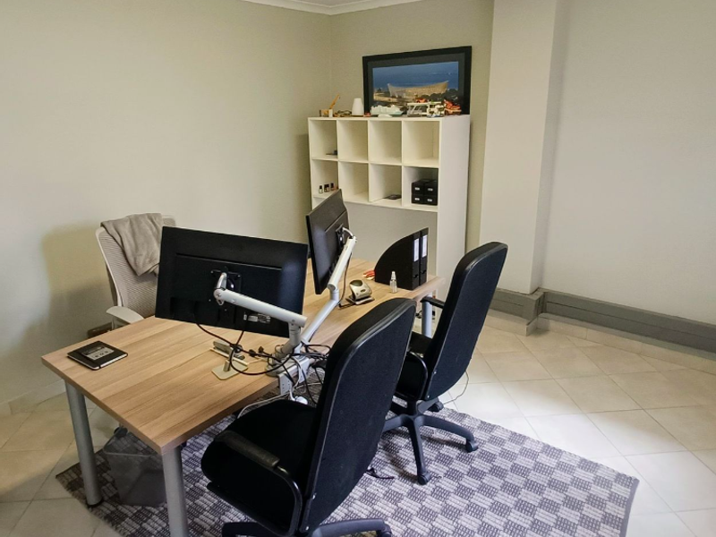 A functional office space featuring tiled flooring and neutral wall finishes, suitable for a professional work environment.