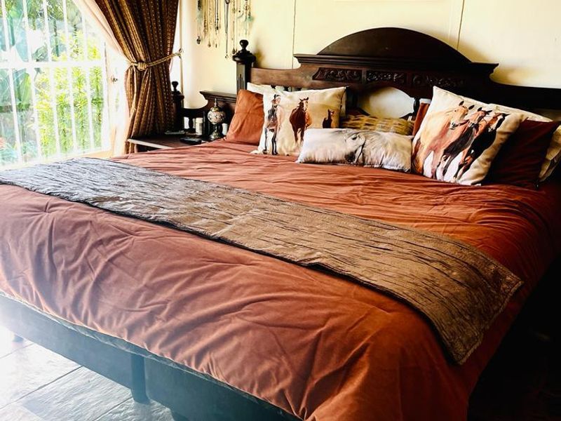 A cozy bedroom featuring durable slate tile flooring and direct access to the outdoors through a secure glass door.