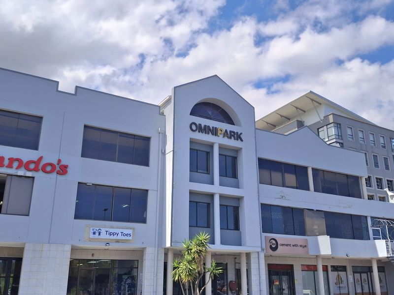 Front elevation of the Omnipark commercial office building featuring multi-level glass storefronts, signage, and dedicated ground-level parking.