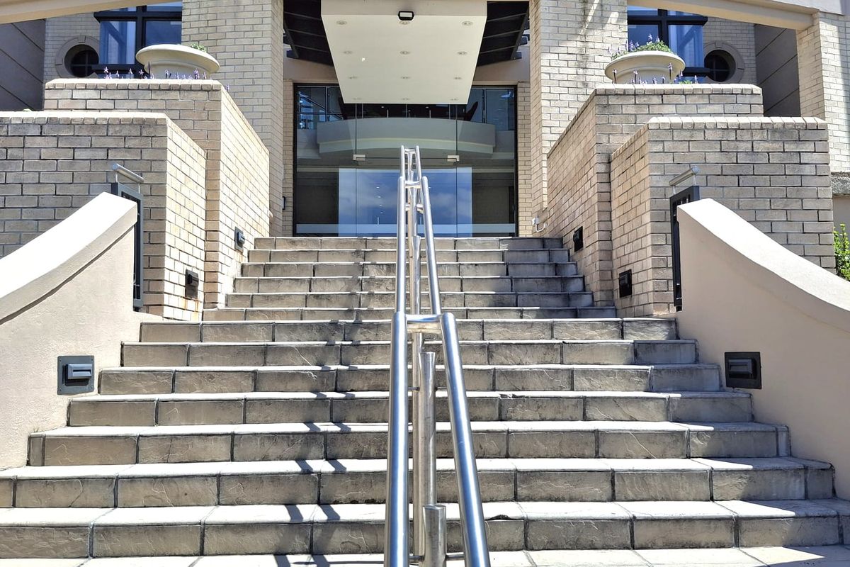 The grand entrance to Waterside Place features a wide stone staircase with a central stainless steel handrail leading to a modern glass doorway.