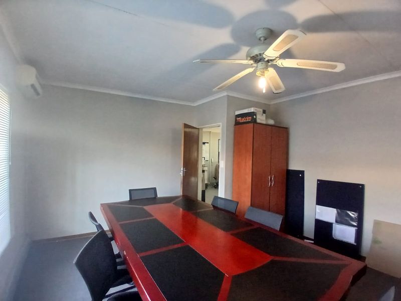 A functional office space featuring a ceiling fan, split-system air conditioning, and built-in storage cabinetry.