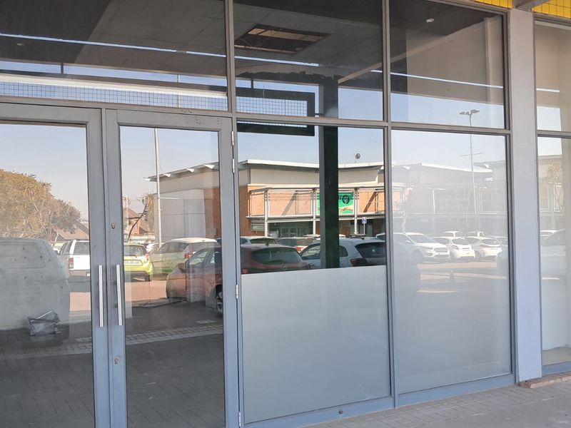 Front entrance of an industrial unit featuring a large glass storefront with aluminium framing and brick exterior detailing.