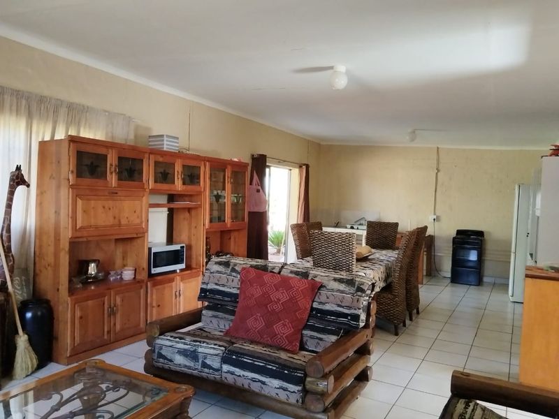 Open plan living and dining area featuring tiled flooring and access to the exterior via a sliding door.