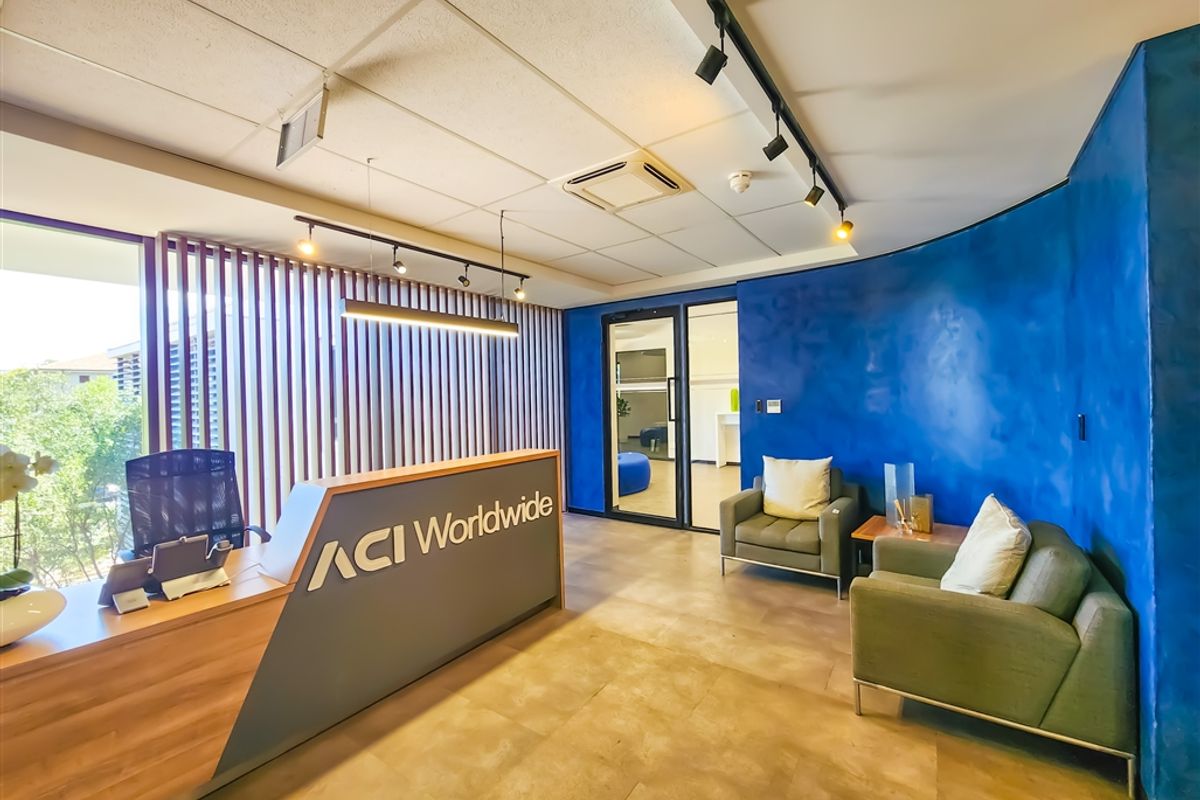 Modern office reception area featuring a custom reception desk, slatted timber privacy screen, and a striking blue feature wall with integrated track lighting.