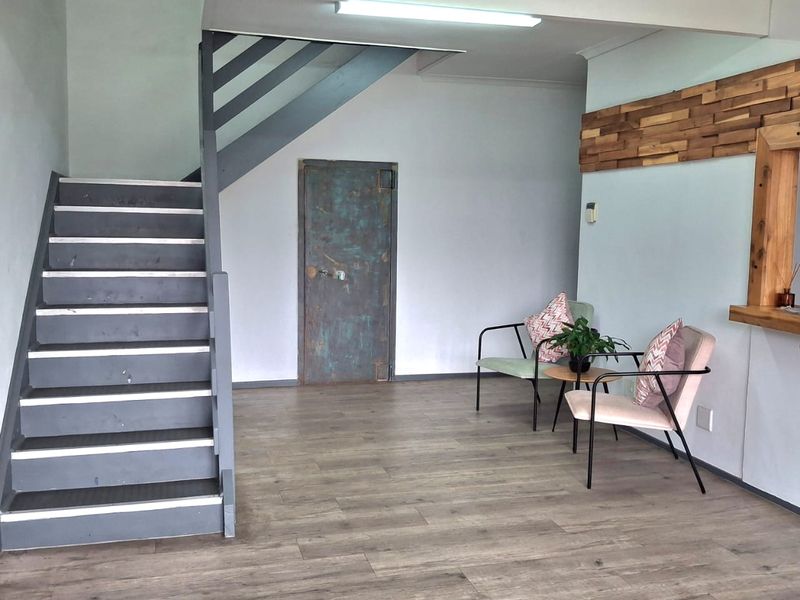 Entrance area featuring a staircase, timber wall accents, and a serving counter, providing a functional transition space within the industrial property.