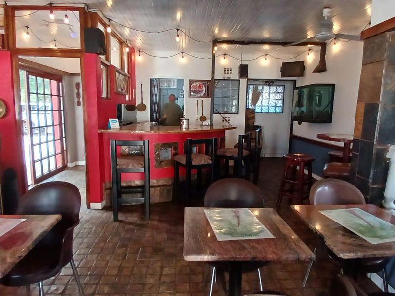 Open plan dining and bar area featuring tiled flooring, timber ceiling, and a built-in bar counter in a guest house setting.