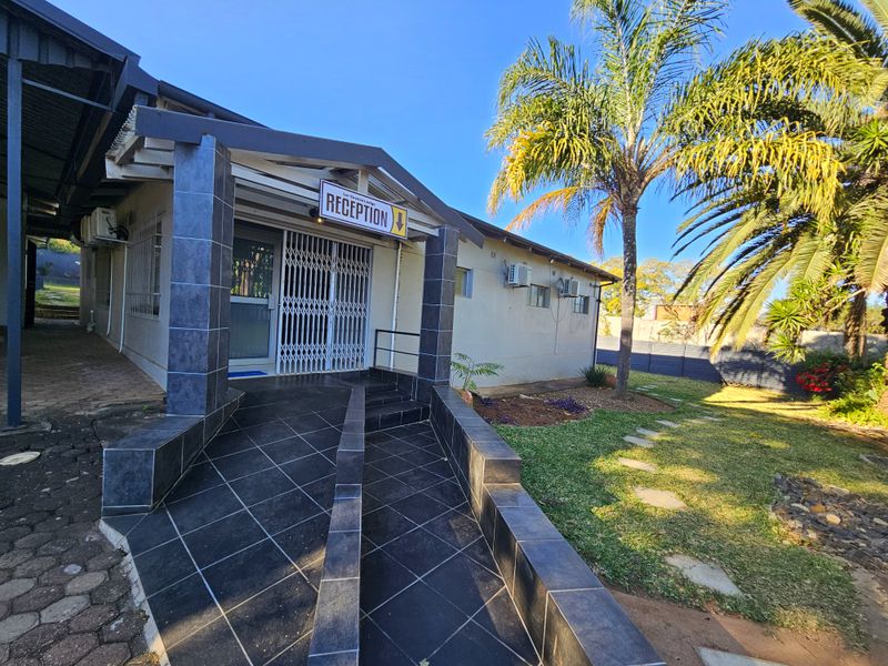 Front entrance of the guest house featuring a tiled wheelchair ramp, security gate, and well-maintained garden area.