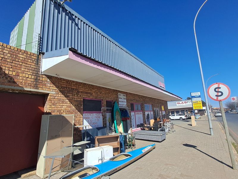 Front elevation of a retail property featuring a face brick facade, corrugated metal upper cladding, and a street-facing awning.