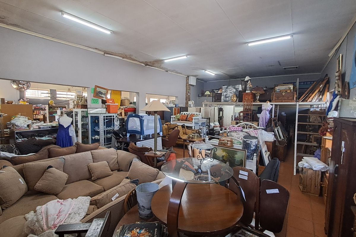 Spacious open-plan retail area featuring a mezzanine level, fluorescent lighting, and tiled flooring, currently utilized for furniture display.