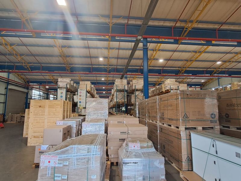 Spacious industrial warehouse facility featuring high-clearance ceilings, exposed steel structural trusses, durable concrete flooring, and large roller shutter access points.